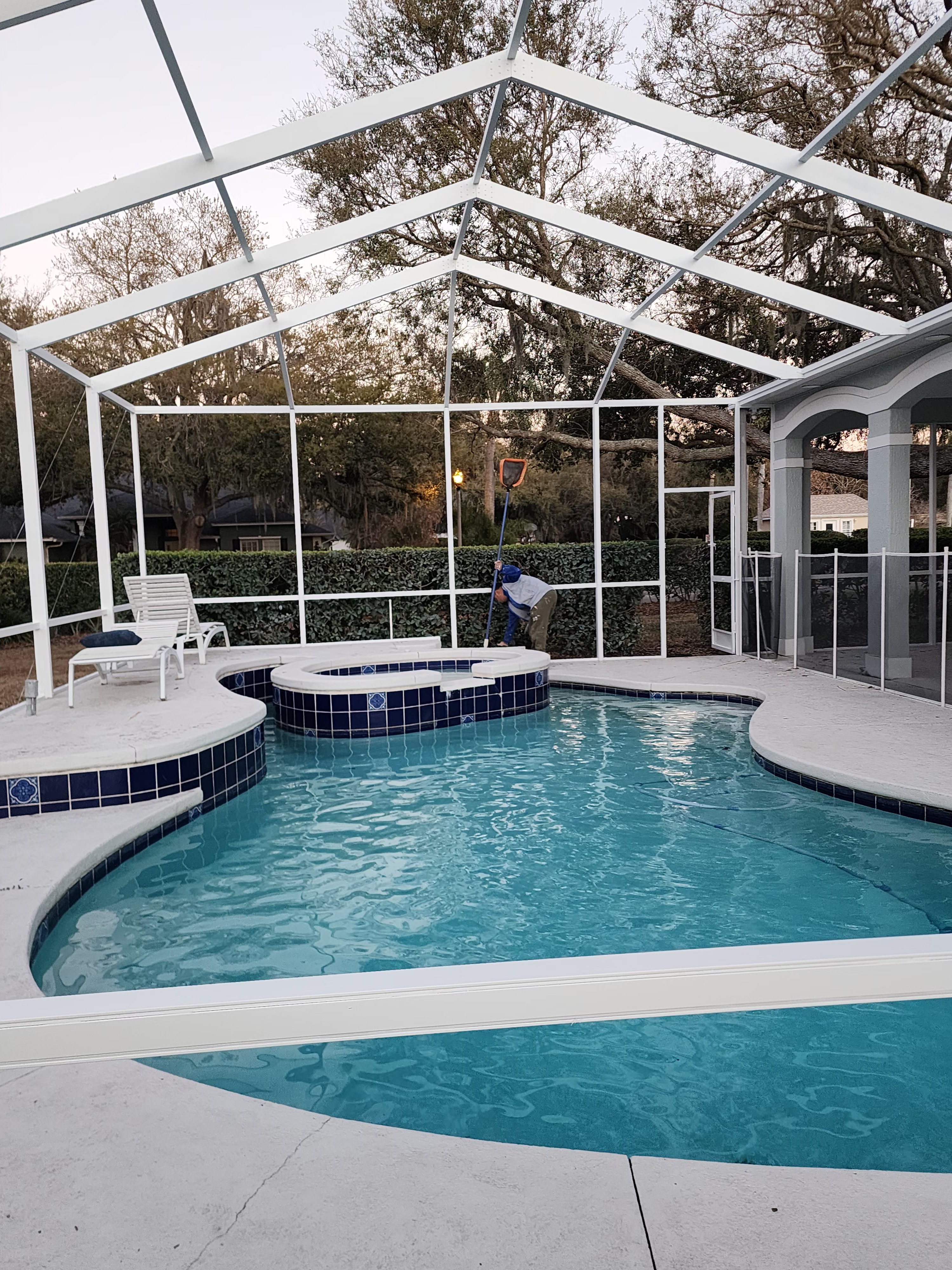 Professional pool cage painting and screen enclosure restoration in Lutz FL by H Calix Stucco Design & Paint LLC — bright white aluminum frame after professional repainting