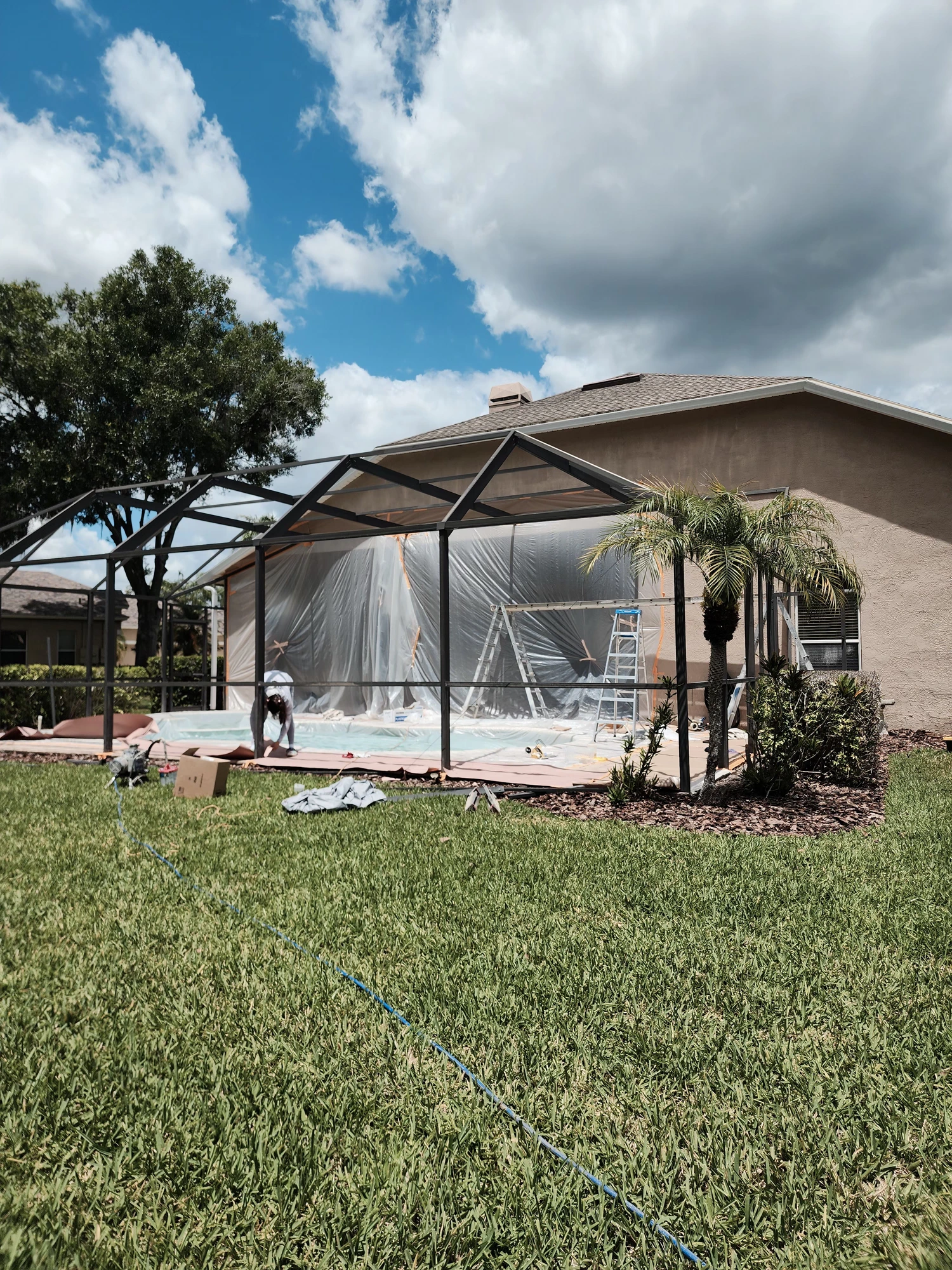 Professional pool cage painting and screen enclosure restoration in Wesley Chapel, Florida by H Calix Stucco Design & Paint LLC — surface preparation and cleaning of aluminum frame