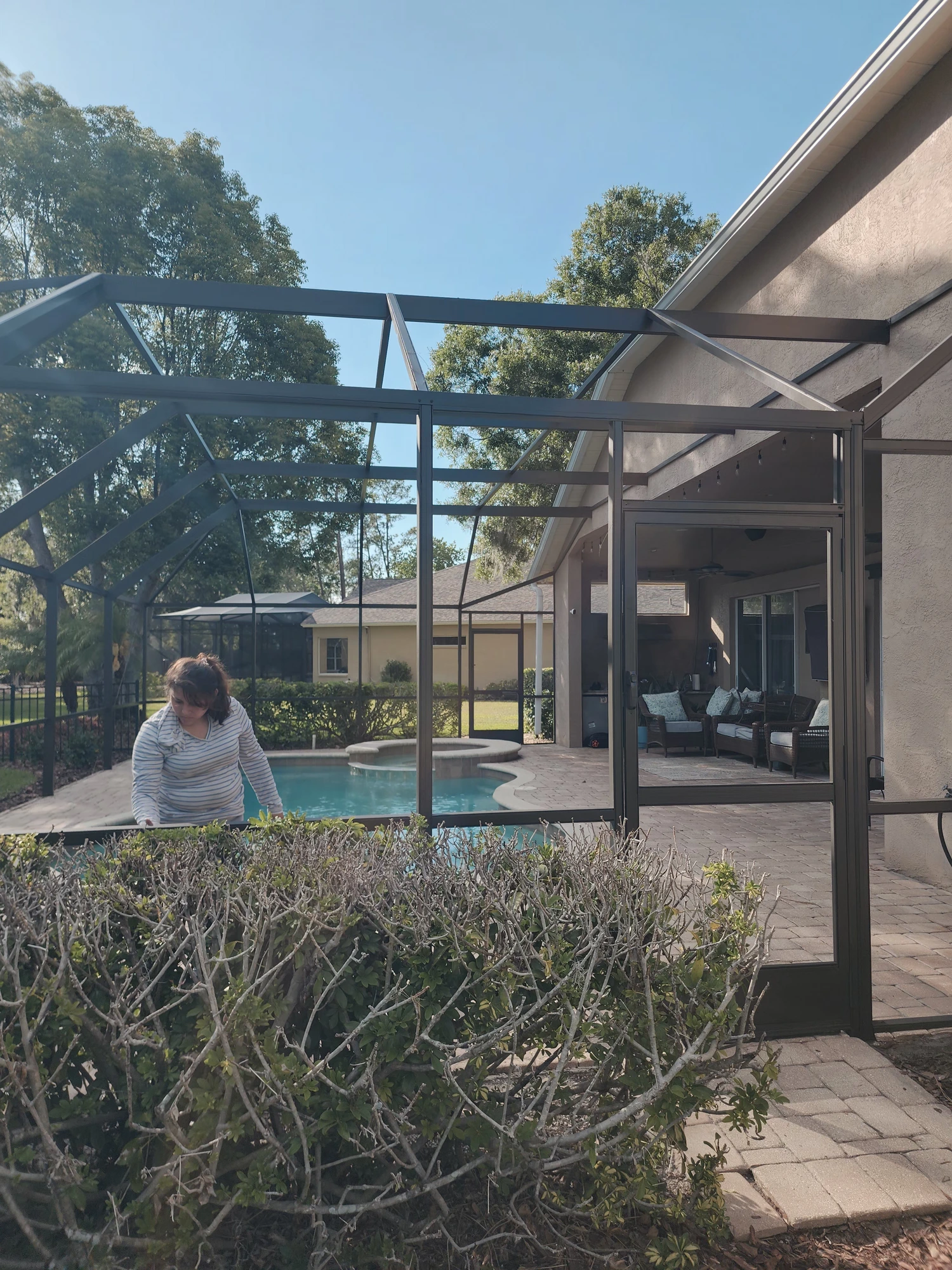 Professional pool cage painting and screen enclosure restoration in Wesley Chapel, Florida by H Calix Stucco Design & Paint LLC — pool and patio fully masked and protected during coating application